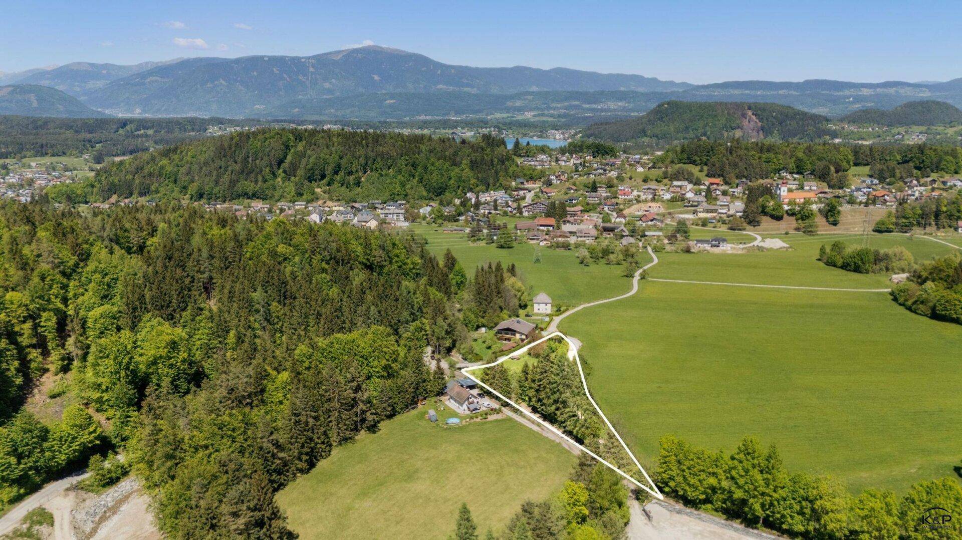 Luftaufnahme einer malerischen Landschaft mit Wäldern, Feldern und einem markierten Grundstück.