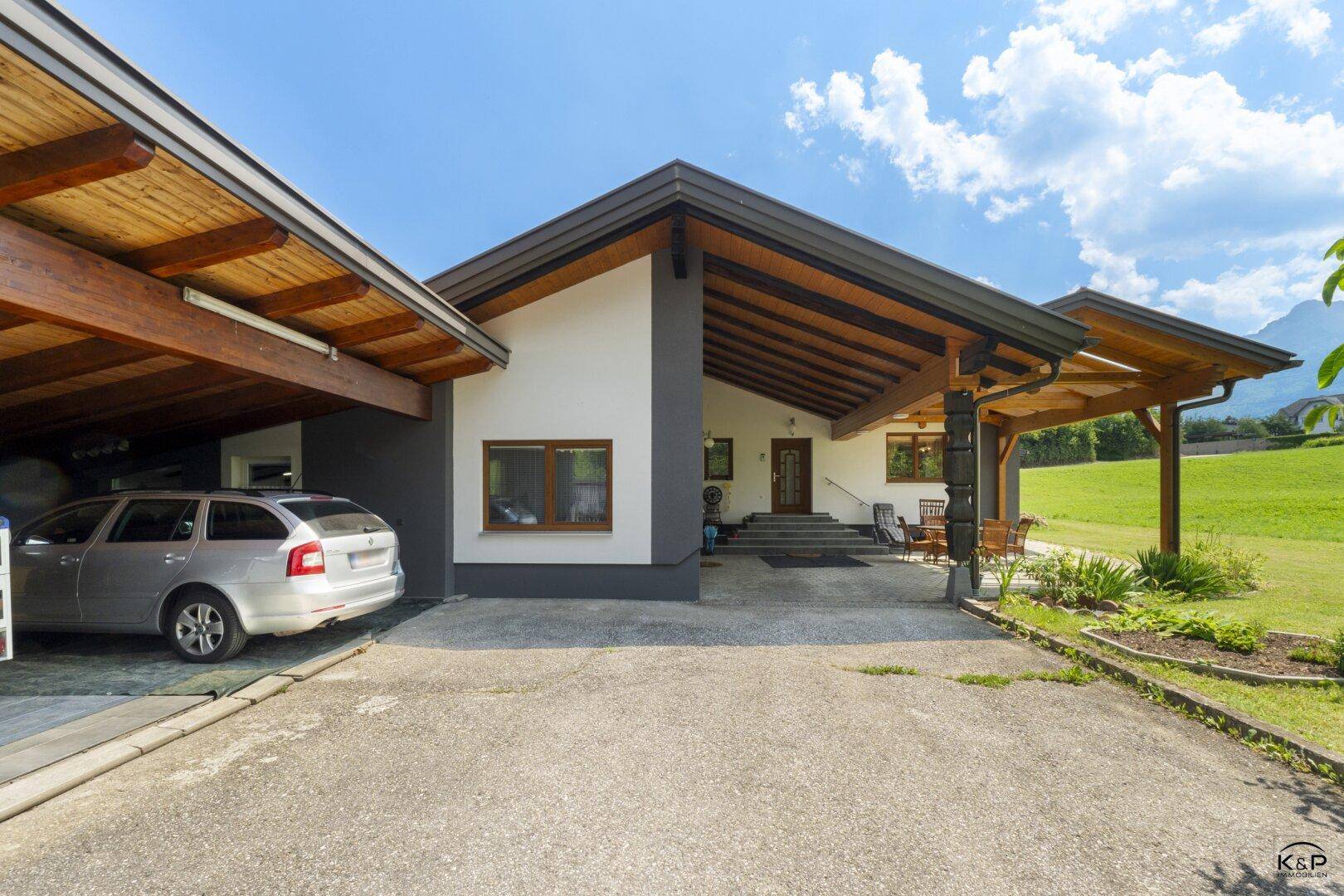 Hauseingang mit überdachtem Carport, Stellplatz und gepflegter Außenanlage.