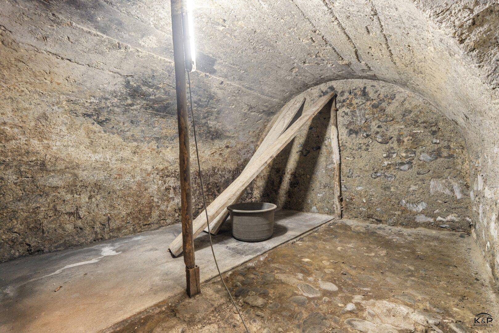Historischer Keller mit Gewölbedecke und Natursteinwänden, ideal zur Lagerung von Wein.