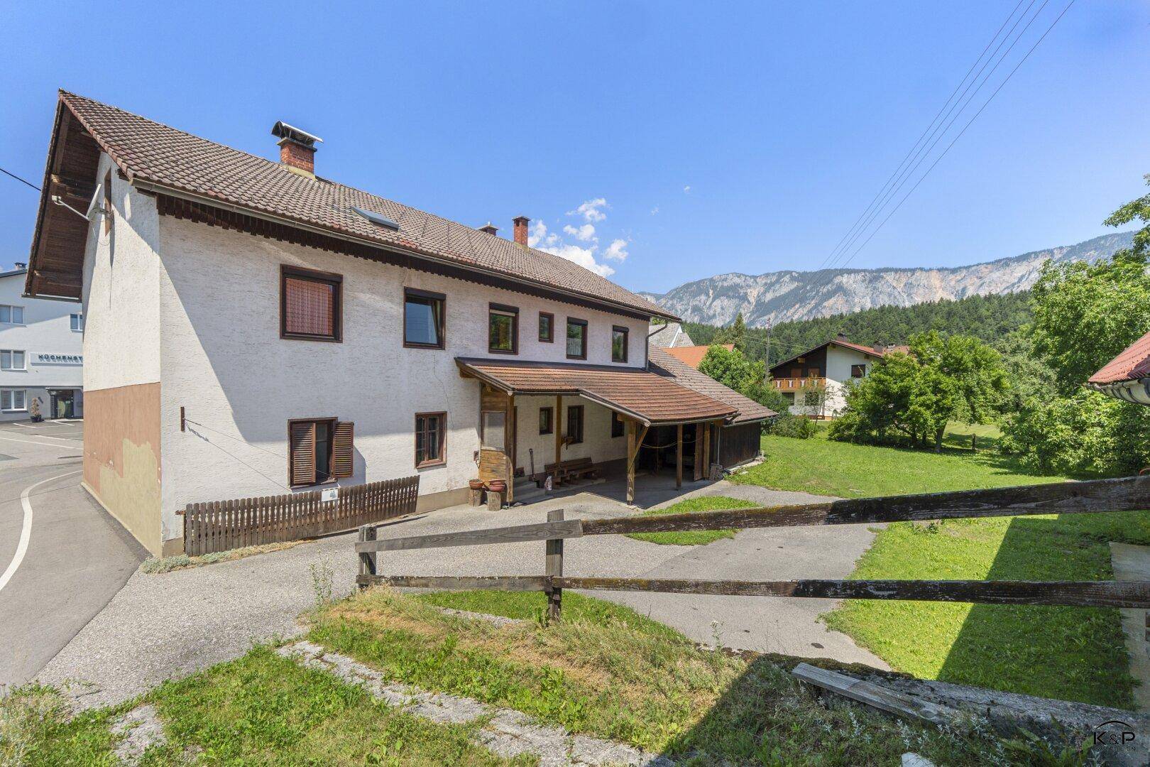 Ansicht des Hauses von der Zufahrt mit traditioneller Architektur und Bergblick.