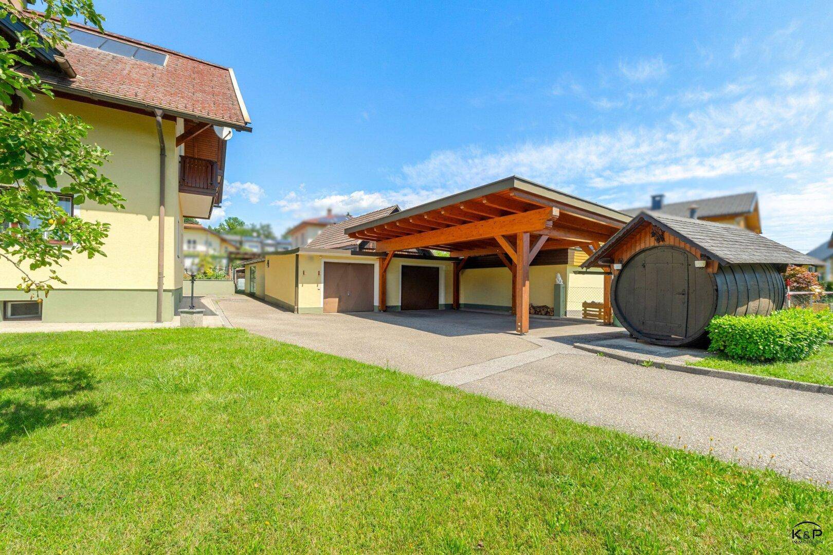 Nebengebäude mit Garage, Carport und einem originellen Fass-Schuppen auf dem Grundstück.