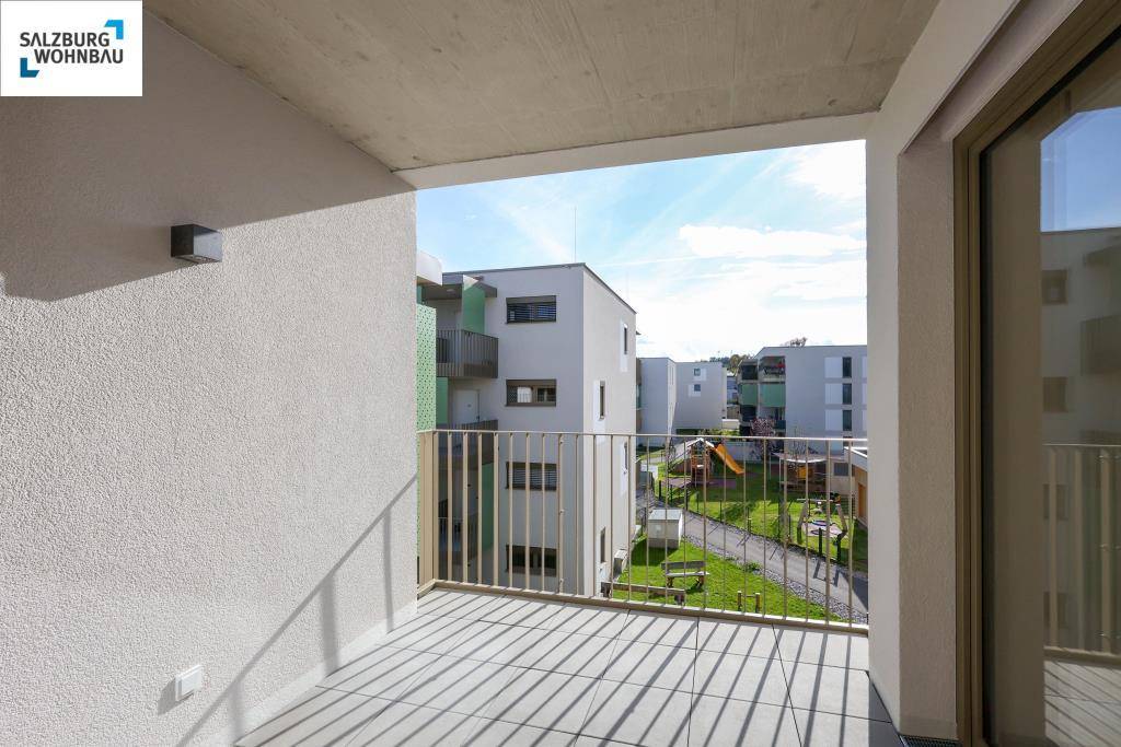 Balkon mit Blick auf die umliegenden Neubauten und einen Kinderspielplatz.