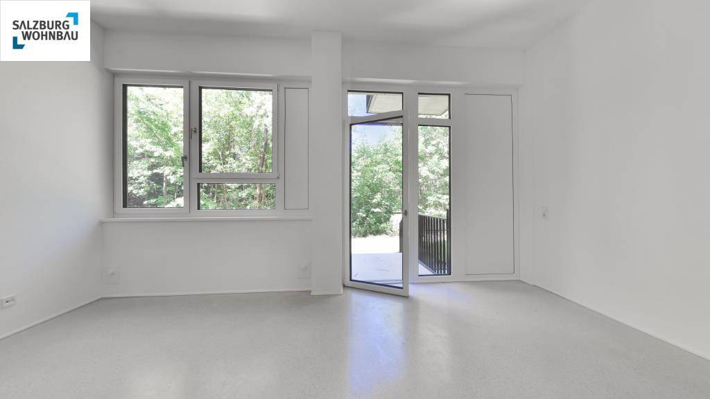 Heller, leerer Raum mit großen Fenstern und Zugang zu einem Balkon oder einer Terrasse, bereit zur Gestaltung.