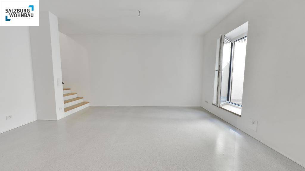 Geräumiger, heller Raum mit großen Fenstern und Zugang zu einem Außenbereich, ideal für Wohnzwecke.