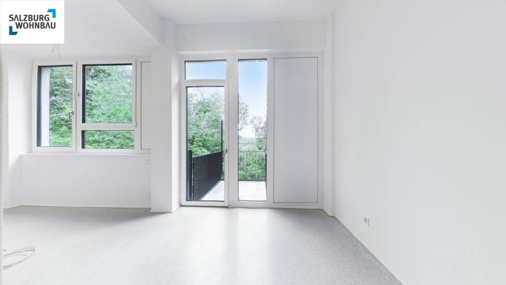 Lichtdurchfluteter, leerer Raum mit großen Fenstern und direktem Zugang zum Balkon.