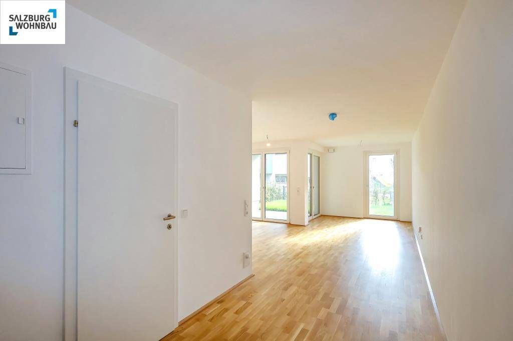 Heller Flur mit Holzboden, der zu weiteren lichtdurchfluteten Räumen führt.