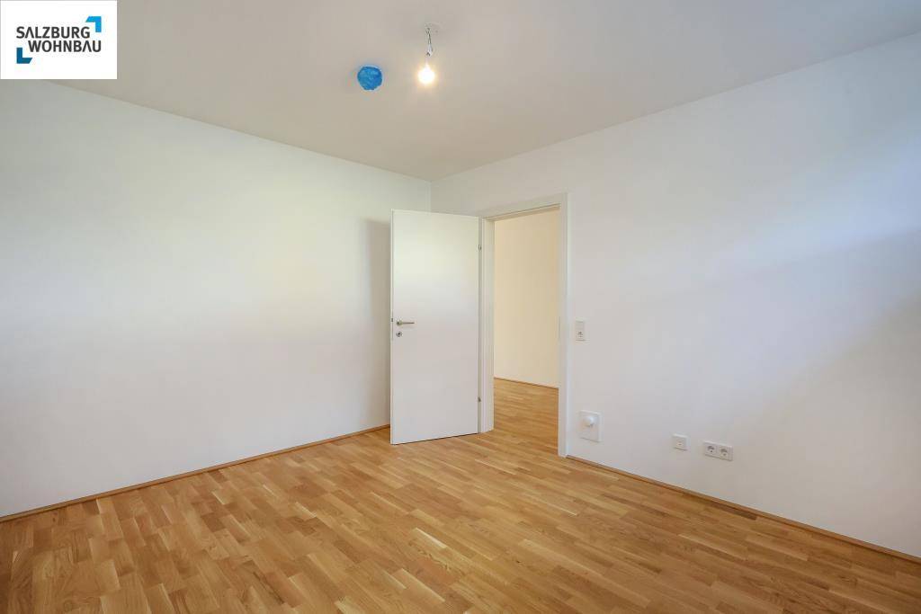 Leerer Raum mit Parkettboden und weiß gestrichenen Wänden, bereit zum Einzug.