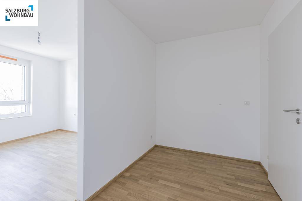 Heller Flur mit Holzboden, der zu weiteren Räumen der Wohnung führt.
