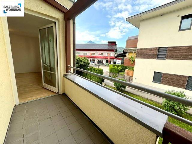Balkon mit Fliesenboden und Blick auf die umliegenden Gebäude und Grünflächen, ideal für entspannte Stunden im Freien.