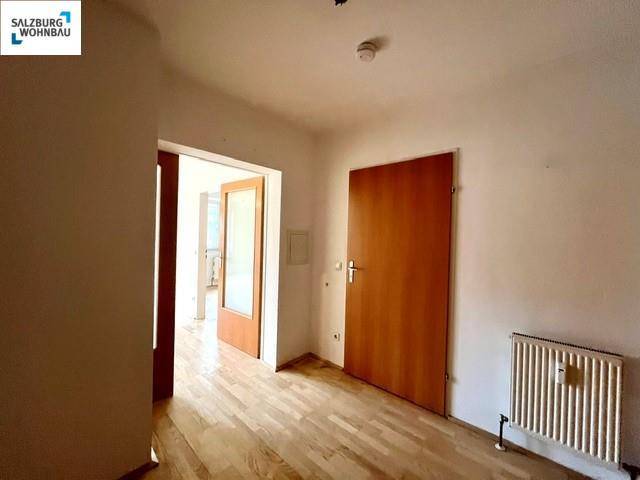 Heller Flurbereich mit Parkettboden und Holztüren, der Zugang zu verschiedenen Zimmern der Wohnung bietet.