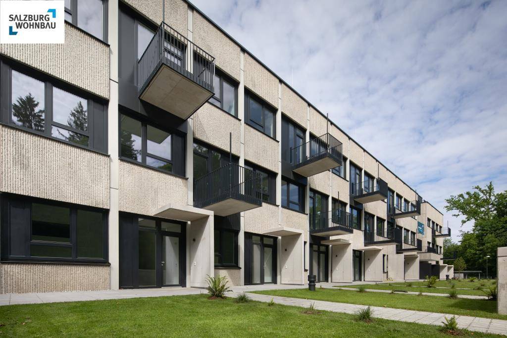 Moderne Wohnanlage mit Balkonen und Zugang zu privaten Gärten im Erdgeschoss.