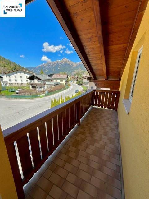 Sonniger Balkon mit Holzbalken und Bergblick, ideal zum Entspannen.