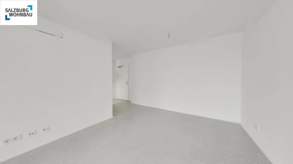 Schlichter, unmöblierter Raum mit hellem Laminatboden und weißen Wänden, ideal für individuelle Gestaltung.