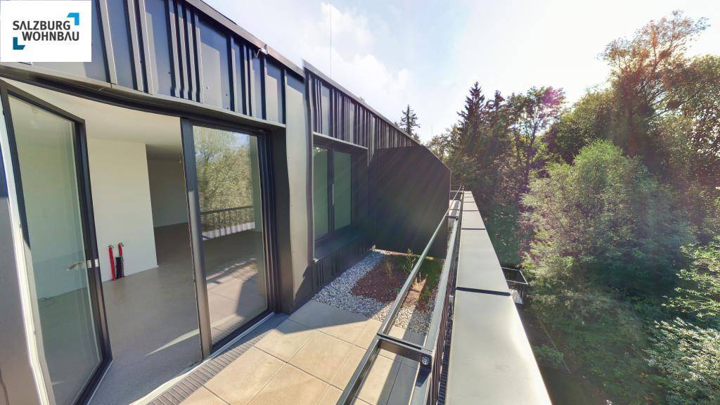 Geräumiger Balkon mit Schiebetüren und Blick auf die umliegende grüne Landschaft.