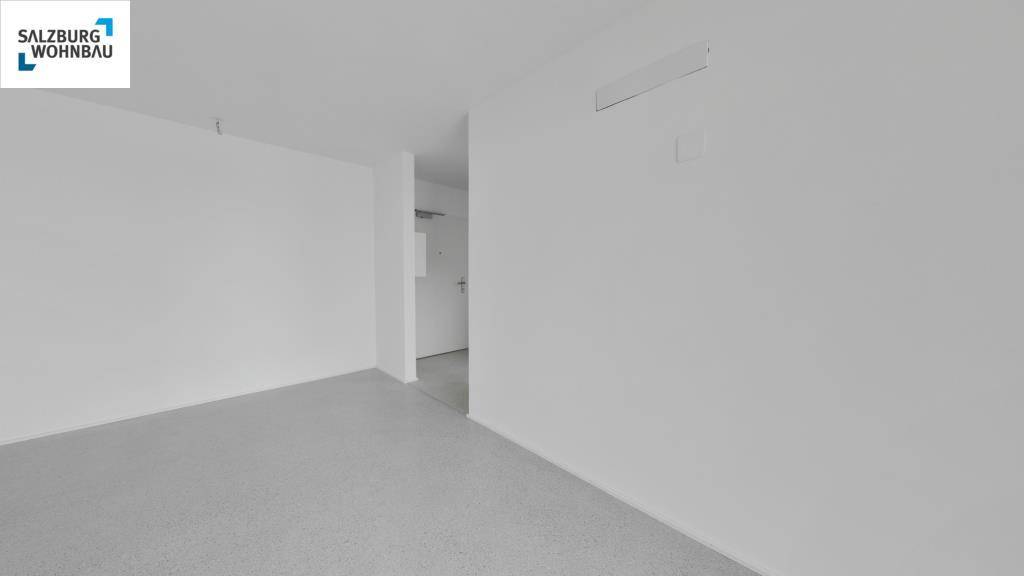 Heller, leerer Raum mit hellem Laminatboden und weiß gestrichenen Wänden, bereit zum Einzug.