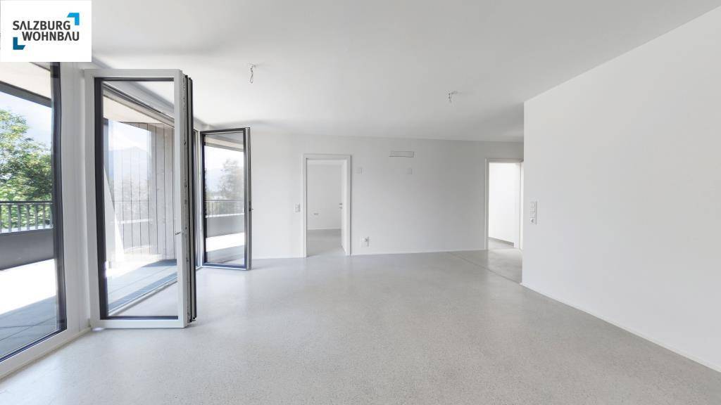 Heller, leerer Wohnbereich mit großen Fenstern und Zugang zu einem Balkon, bereit zur individuellen Gestaltung.