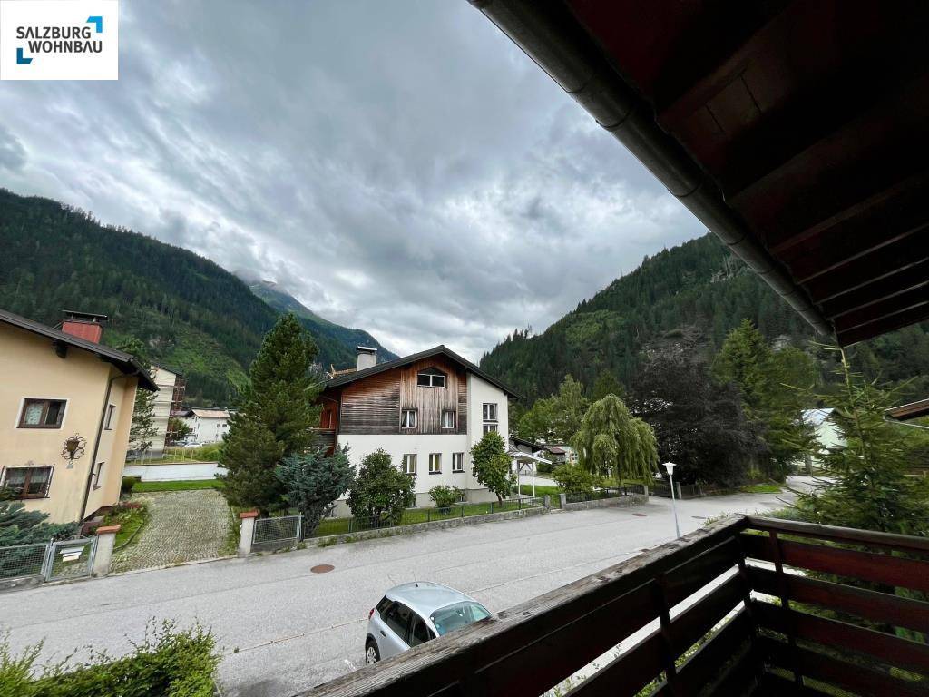 Ausblick vom Balkon auf die umliegende Berglandschaft und Nachbargebäude.