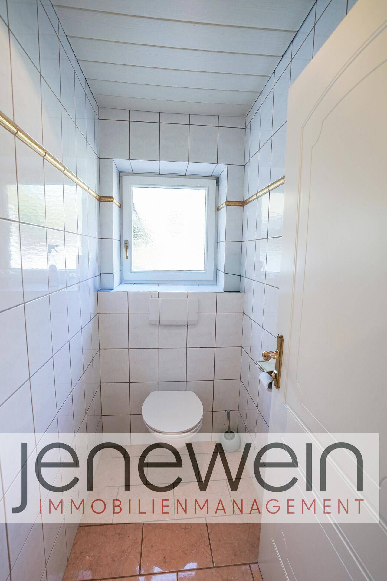 Kleines Gäste-WC mit weißen Fliesen, Fenster und Wand-WC.