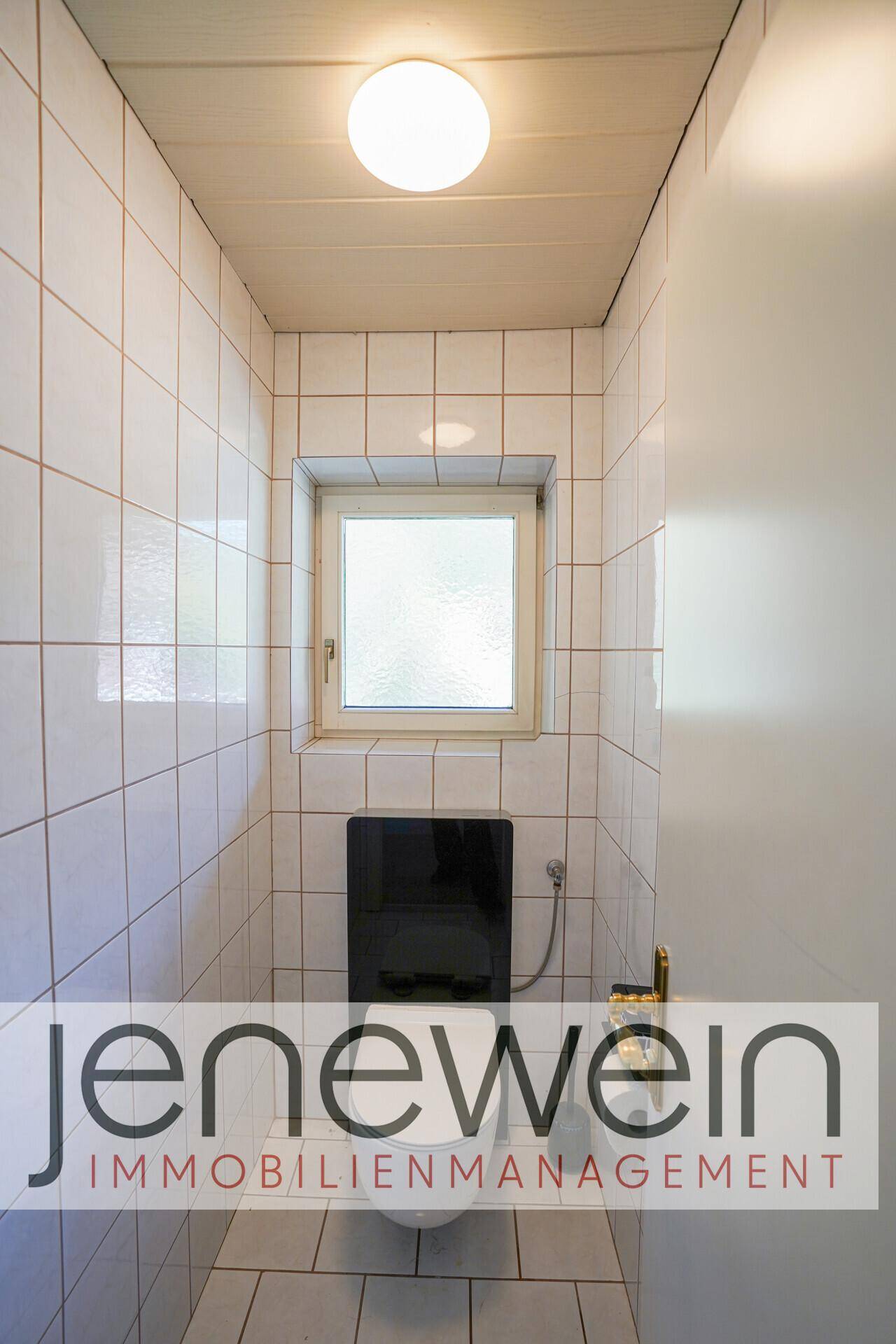 Einfaches Gäste-WC mit weißen Fliesen, Fenster und Wand-WC.