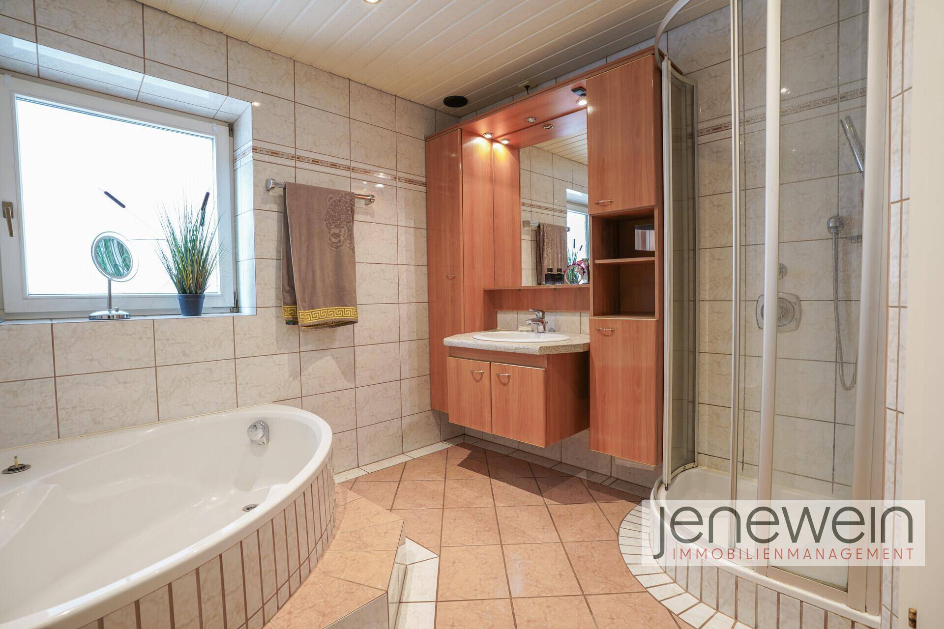 Geräumiges Badezimmer mit Badewanne, Dusche und Holzwaschtisch.