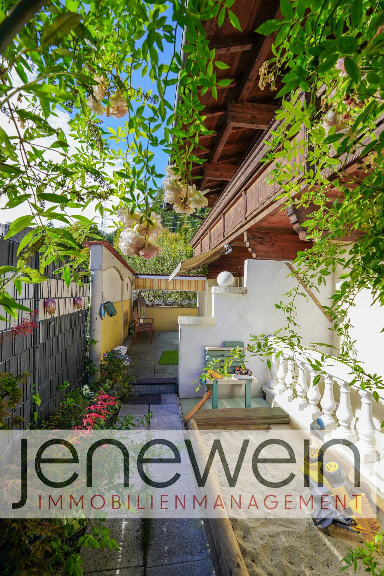 Malerischer Gartenweg mit üppiger Bepflanzung und Zugang zu einer weiteren Terrasse.