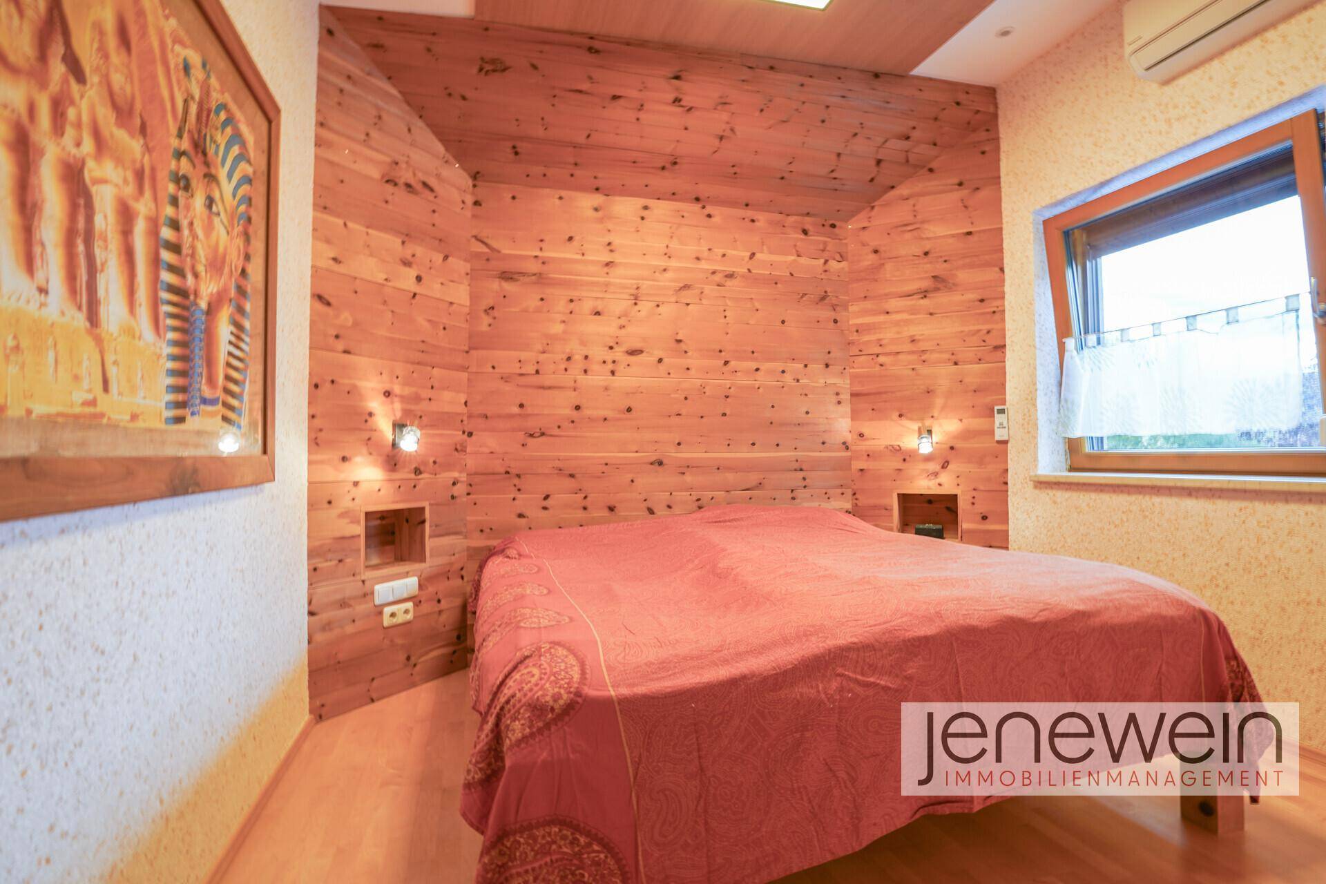Schlafzimmer mit Holztäfelung, Doppelbett und natürlichem Lichteinfall durch das Fenster für erholsamen Schlaf.