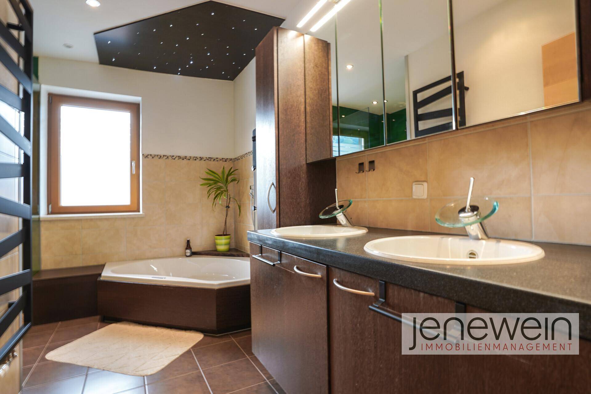 Geräumiges Badezimmer mit Doppelwaschbecken, Eckbadewanne und Sternenhimmel-Decke für Entspannung.