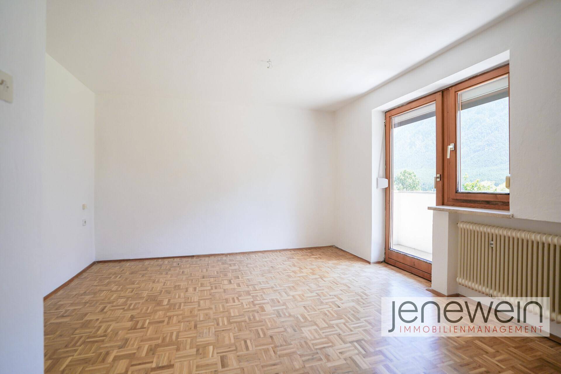 Helles Schlafzimmer mit Parkettboden und Balkonzugang, bietet viel Gestaltungspotenzial.