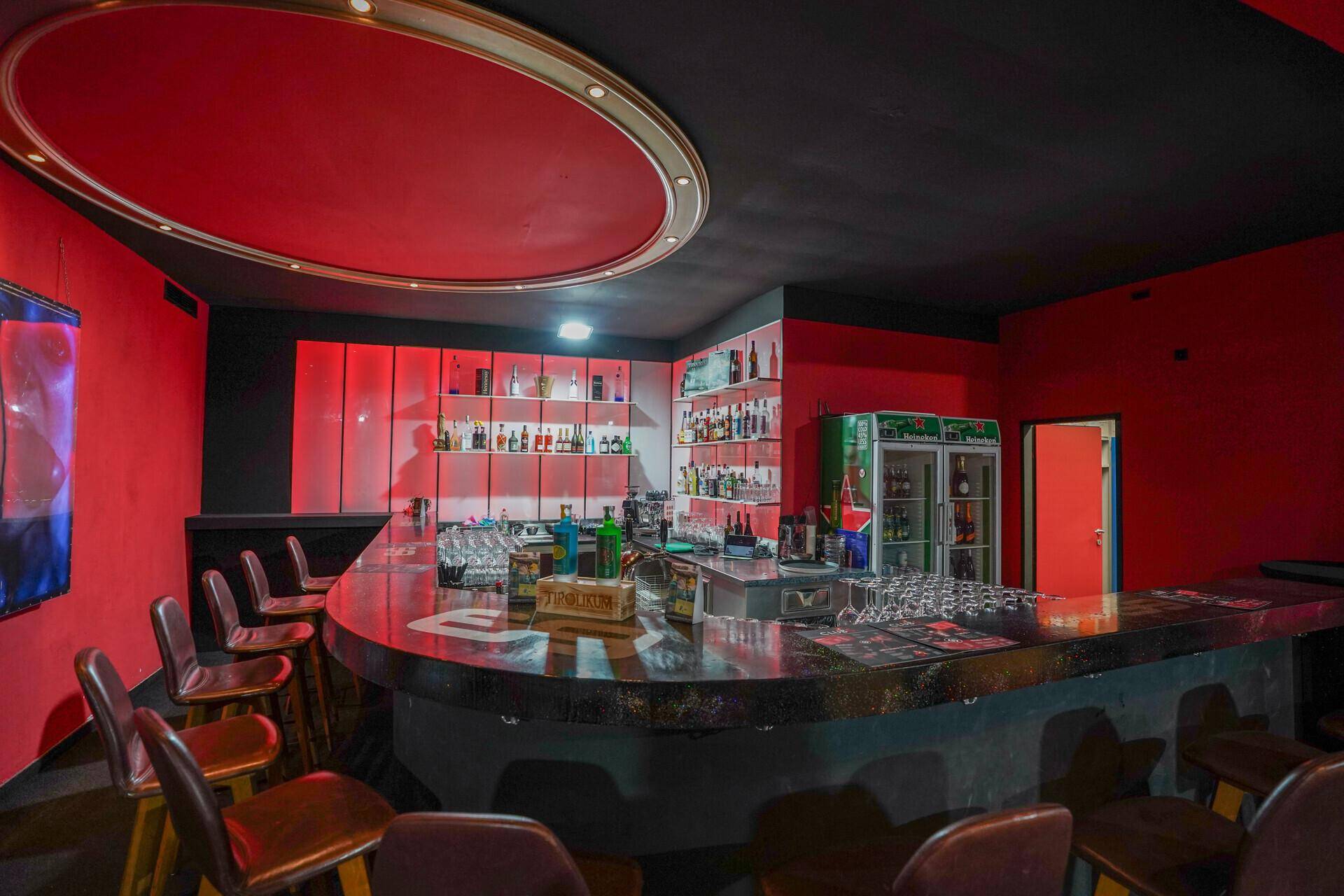 Detaillierter Blick auf die Bar mit Flaschen, Gläsern und der glänzenden Thekenoberfläche.
