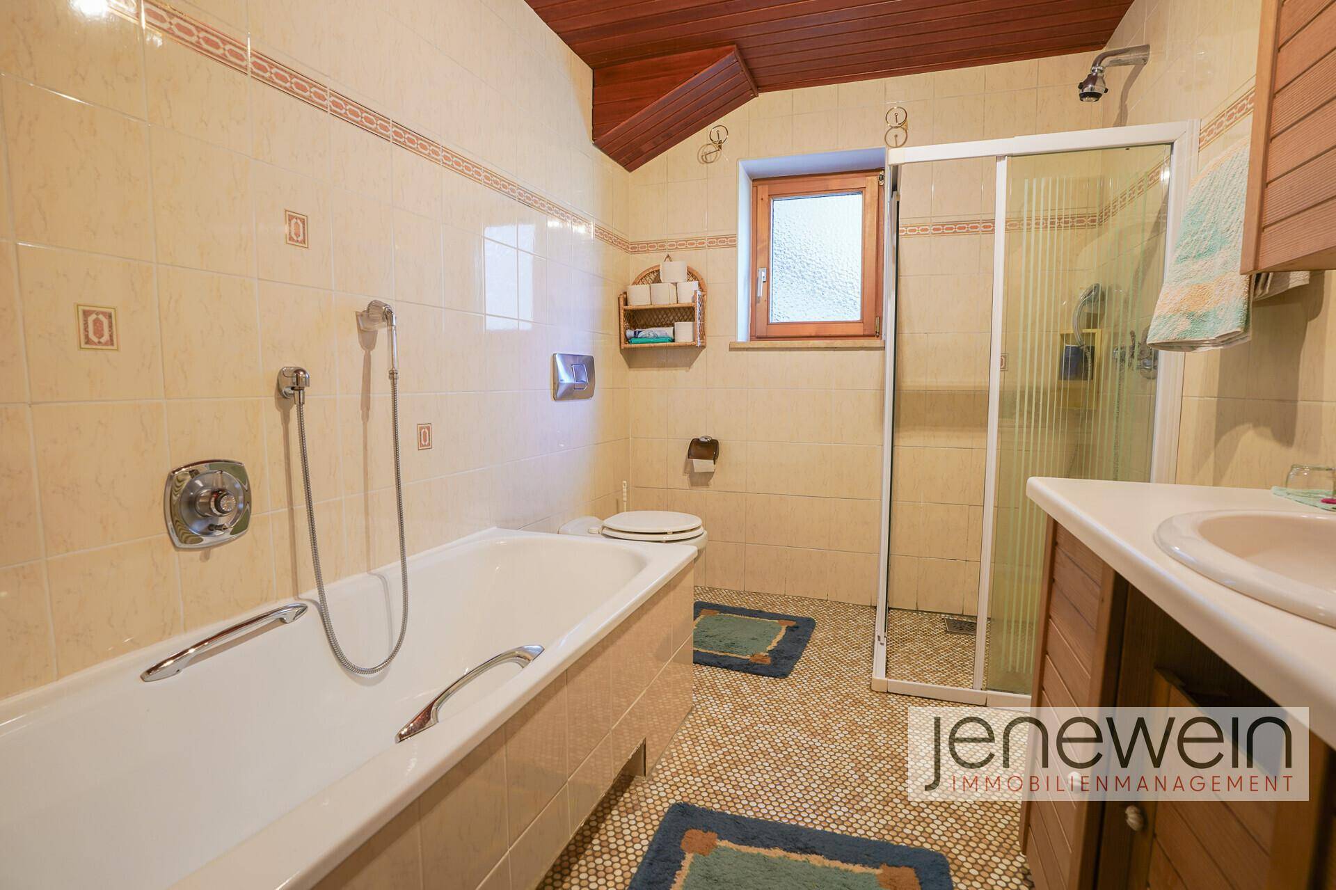 Badezimmer mit Badewanne, Dusche und Holzdecke im traditionellen Stil.