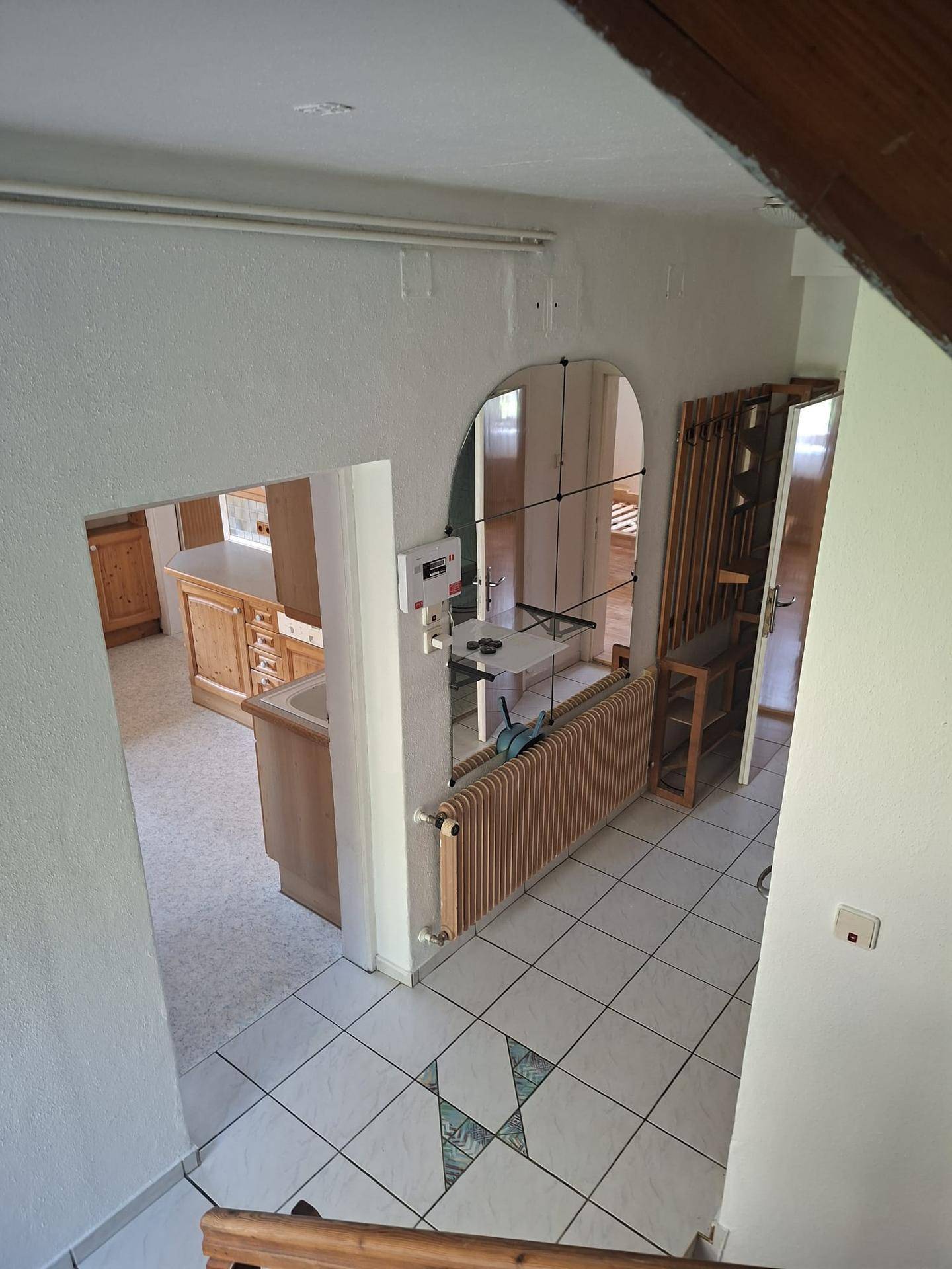 Blick vom Treppenabsatz in den Flur und die angrenzende Küche.