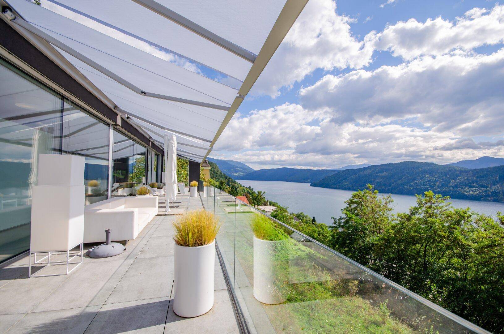 Großzügige Außenterrasse mit Sonnenschutz und unvergleichlichem Panoramablick über den See.