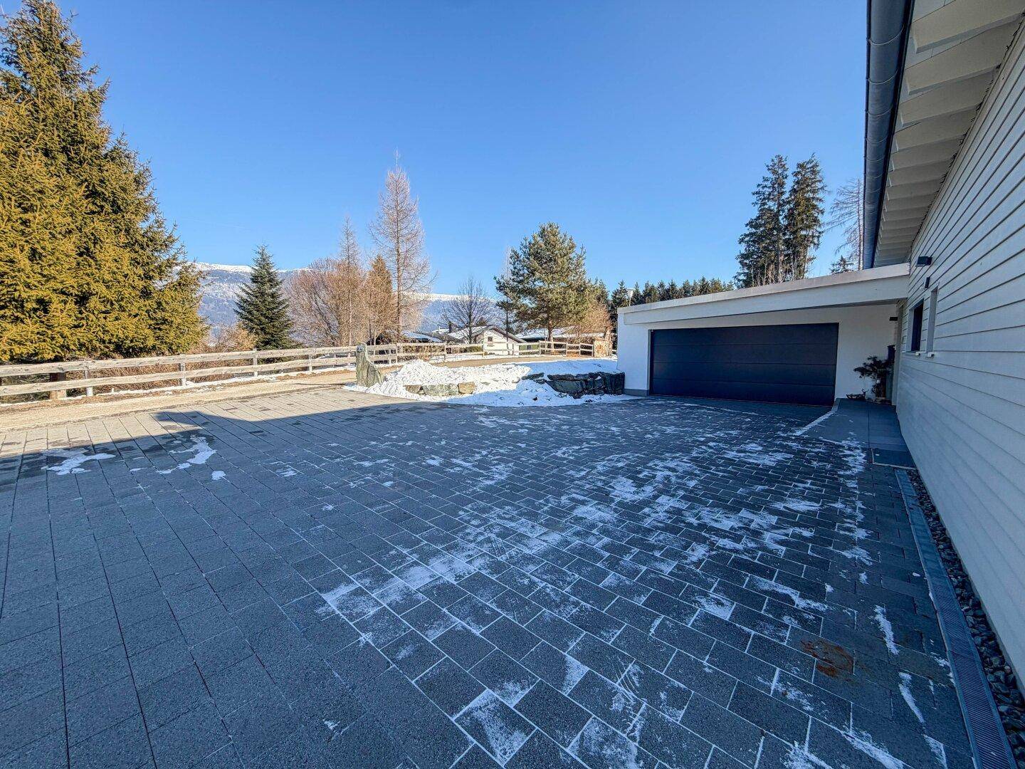 Große gepflasterte Auffahrt mit Doppelgarage und ausreichend Parkmöglichkeiten vor dem Haus.