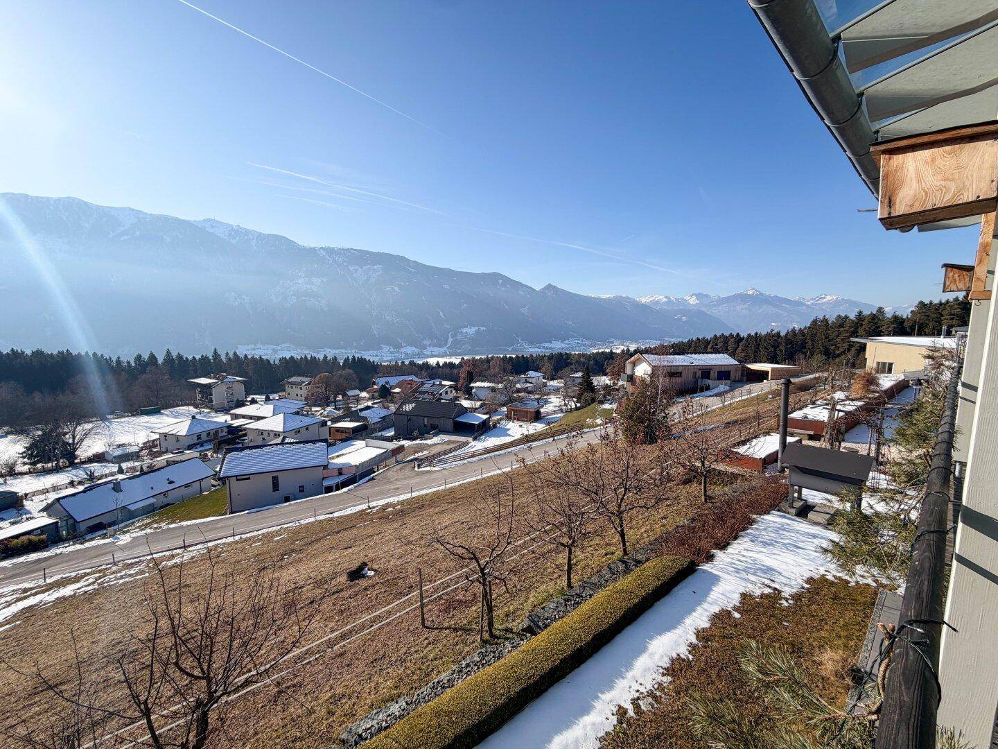 Panoramablick von der Immobilie auf die umliegende schneebedeckte Landschaft, Dörfer und majestätische Berge.