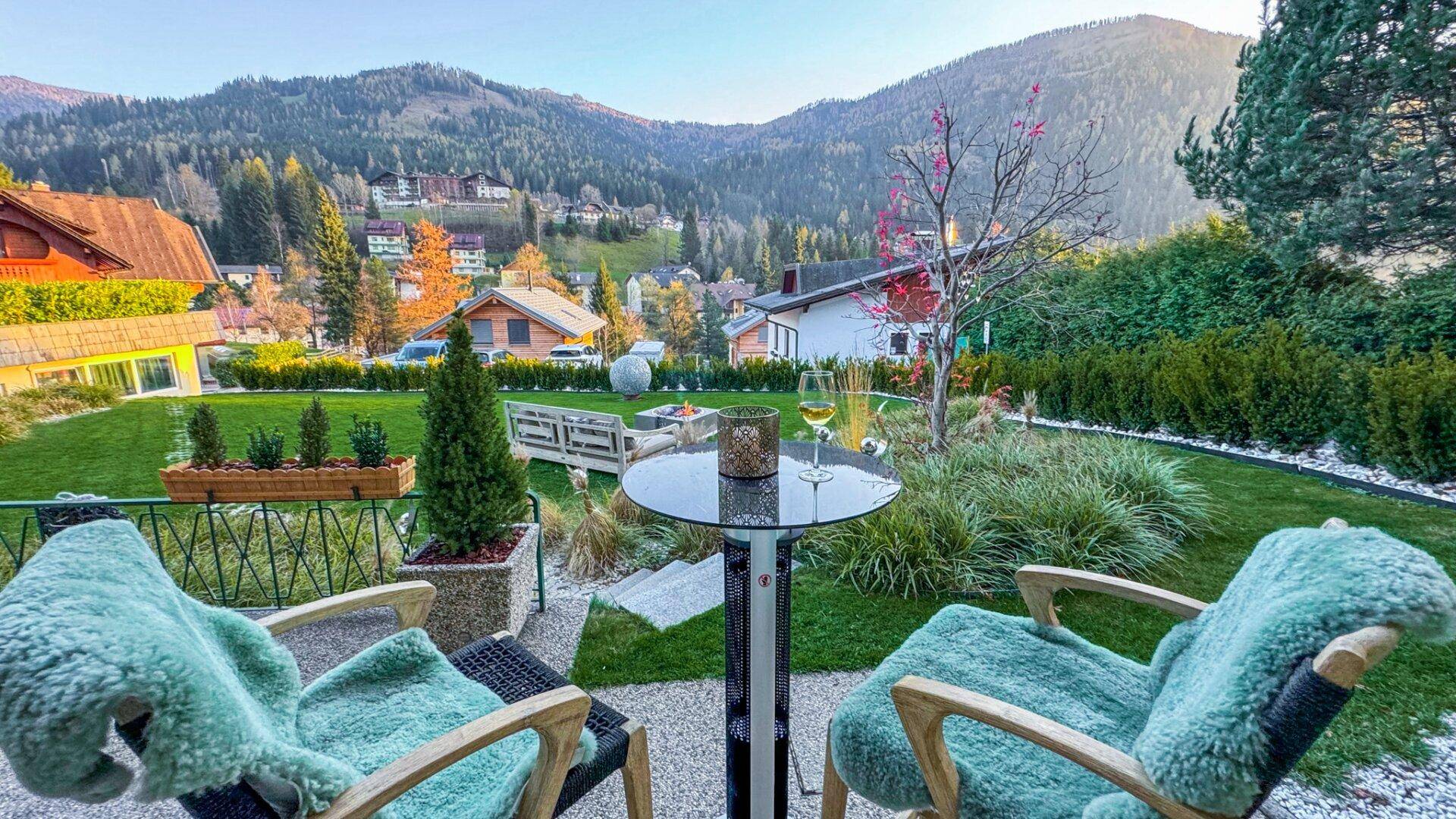 Gepflegter Gartenbereich mit Sitzgelegenheiten und weitem Blick auf die malerische Bergkulisse.