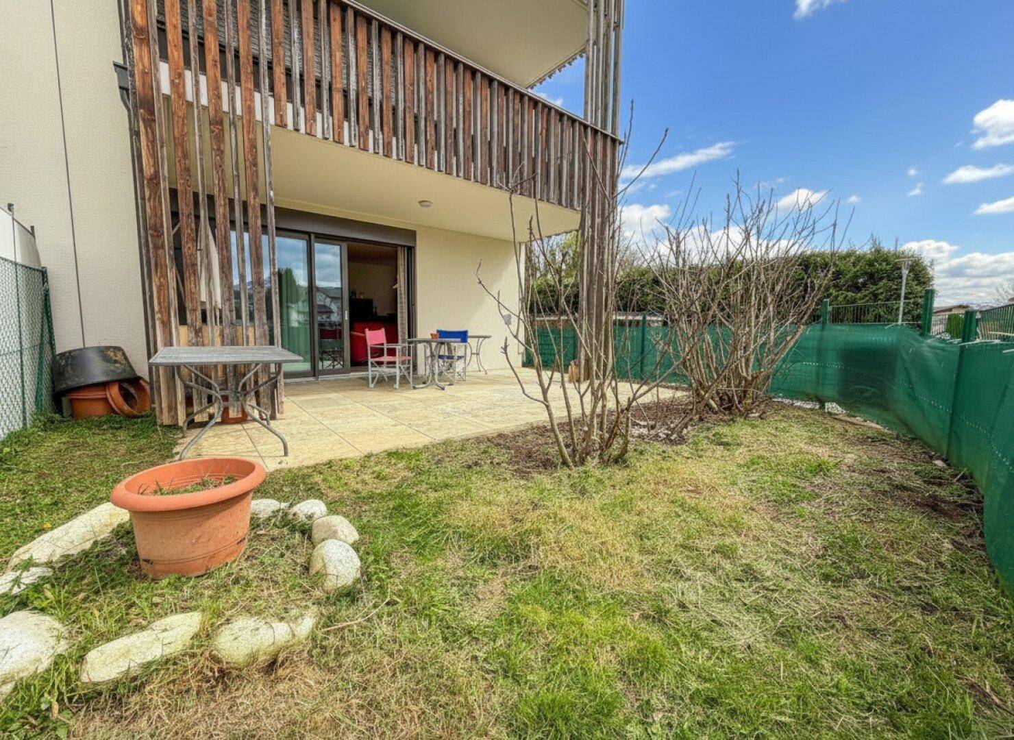 Erdgeschoss-Terrasse mit angrenzendem Gartenbereich und Blick auf die umliegende Bebauung.