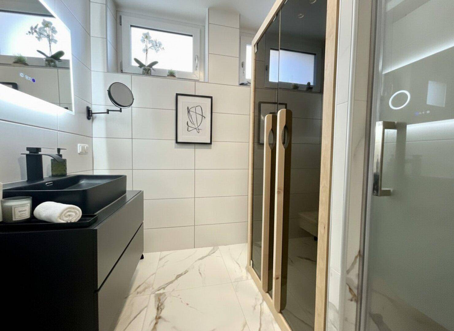 Modernes Badezimmer mit Sauna, begehbarer Dusche und stilvollen Fliesen.