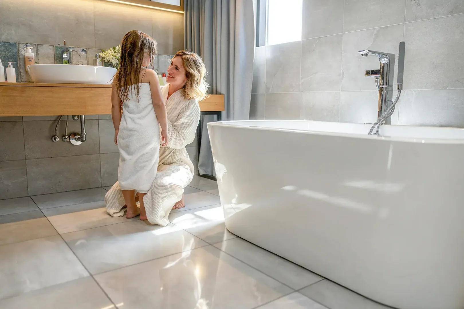 Helles, modernes Badezimmer mit freistehender Badewanne und großformatigen Fliesen.