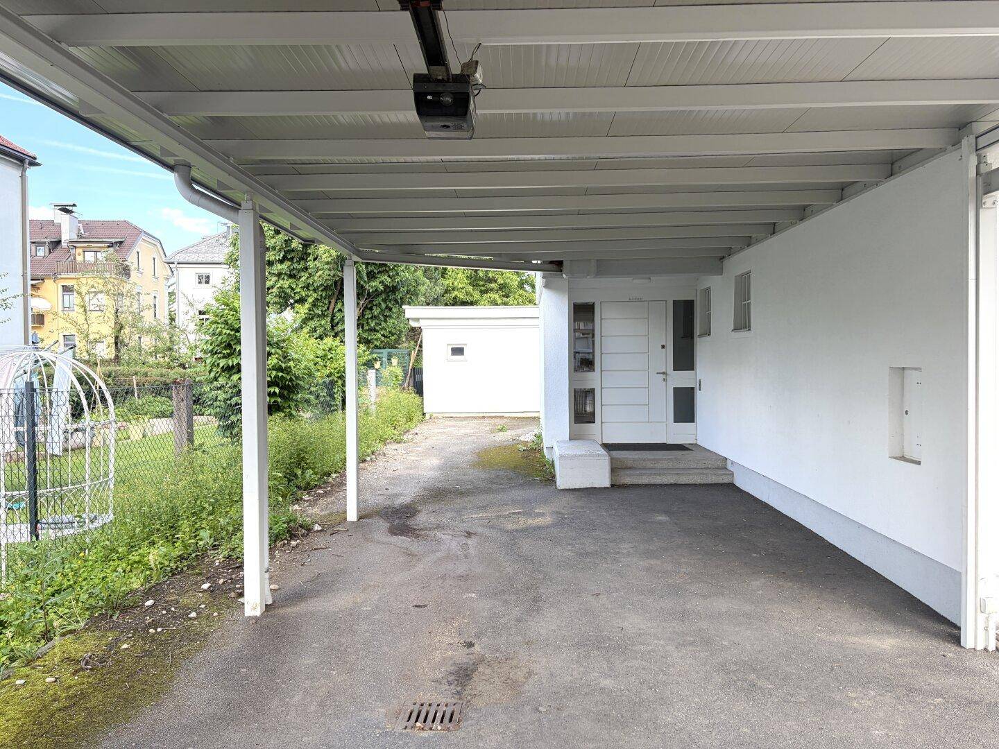 Überdachter Carport-Bereich mit direktem Zugang zum Hauseingang.