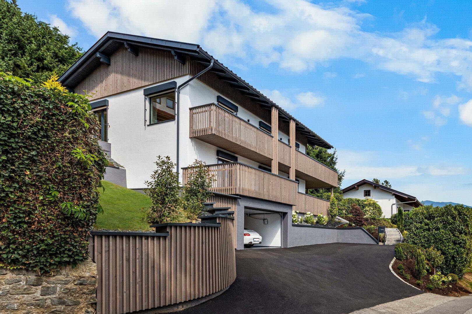 Moderne Architektur mit Holzfassade, Balkonen und integrierter Tiefgarage.