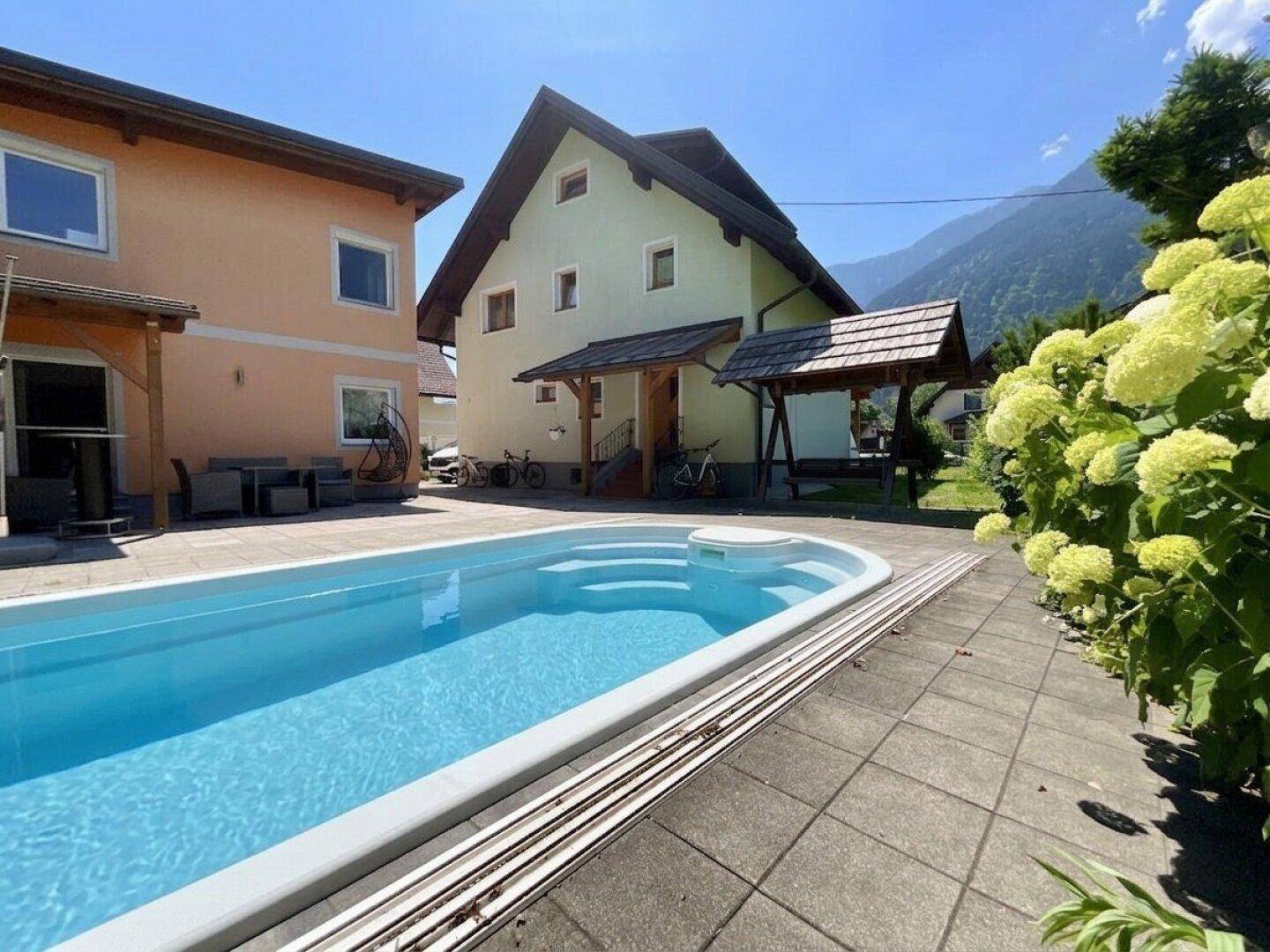 Blauer Swimmingpool im Außenbereich mit Blick auf die umliegenden Berge.