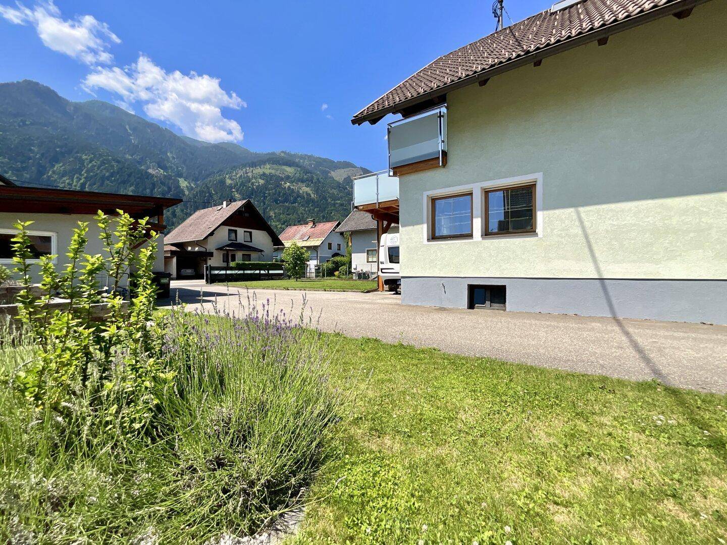 Gepflegte Rasenfläche mit Pflanzen und einem weiten Blick auf die Berglandschaft.