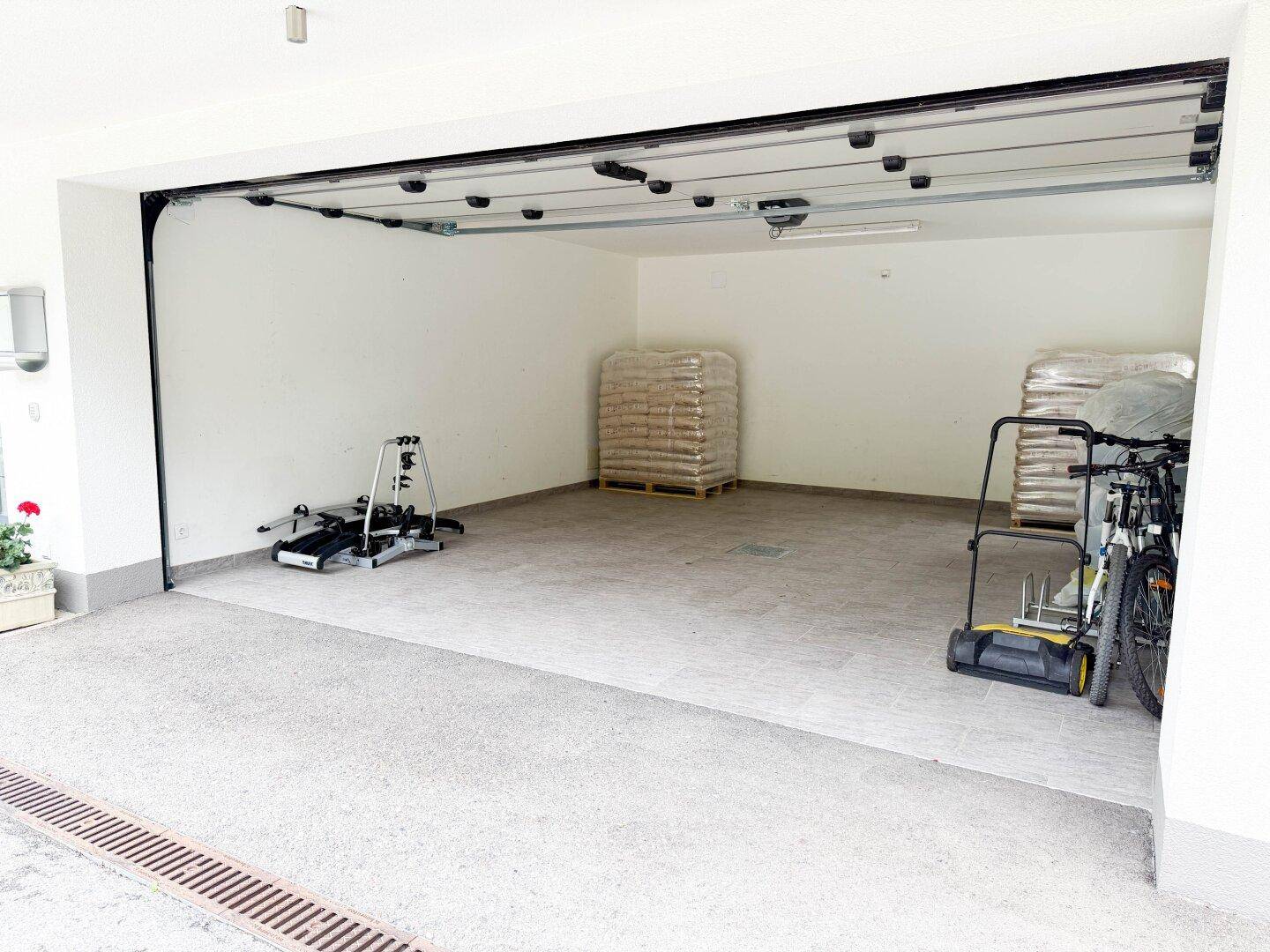 Leere Garage mit ausreichend Platz für Fahrzeuge und Lagerung von Sportgeräten.
