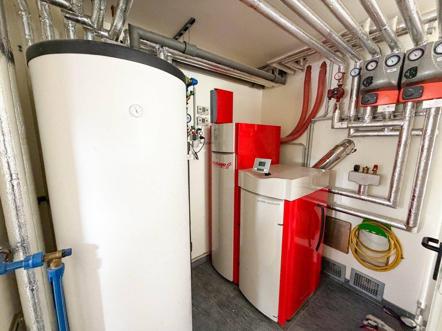 Technikraum mit Heizungsanlage und Warmwasserspeicher, gut organisiert und funktional.