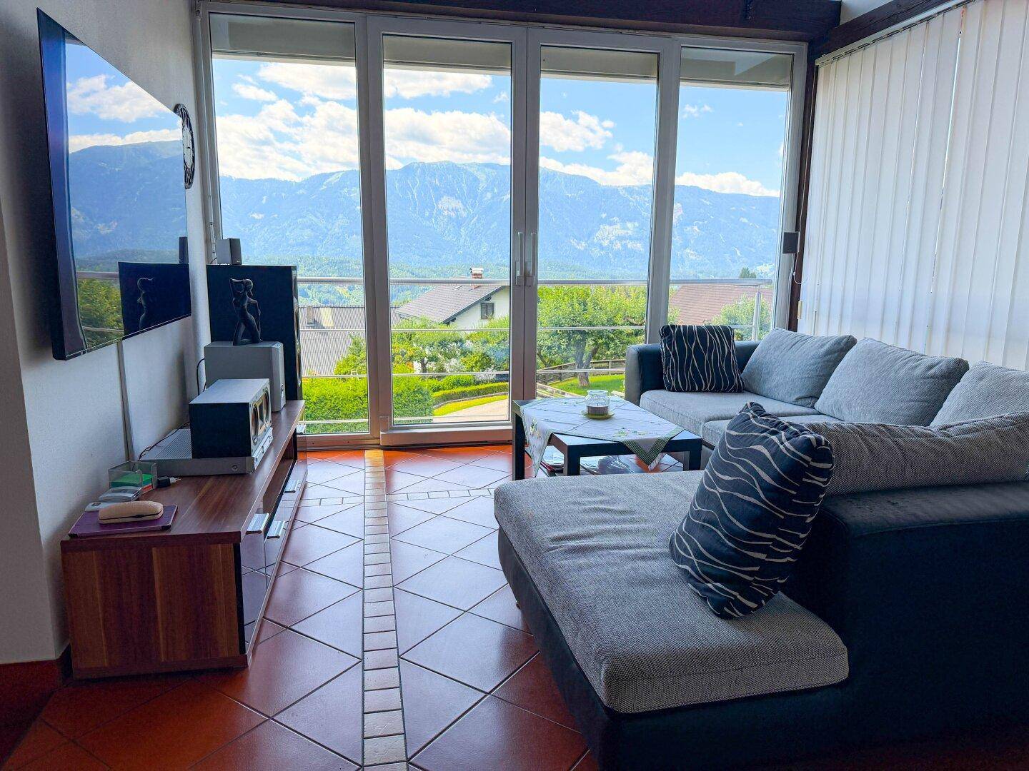 Helles Wohnzimmer mit großen Fenstern und atemberaubendem Bergblick.