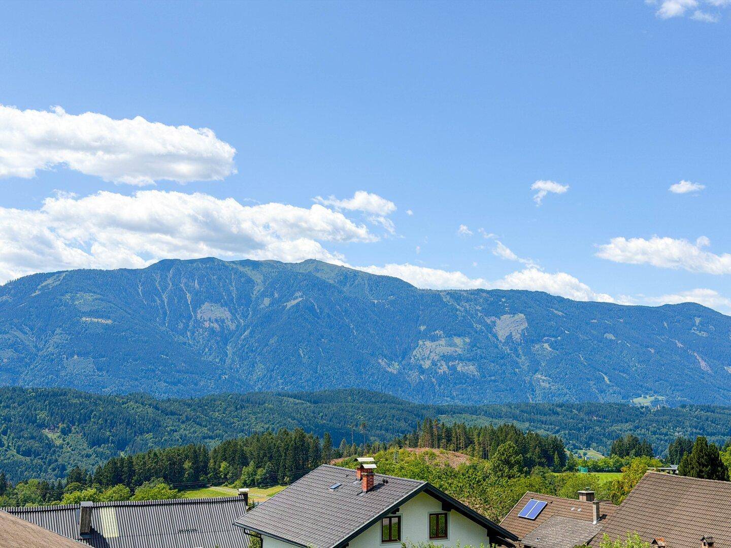 Weitläufiger Panoramablick auf die umliegende Berglandschaft und Dächer.