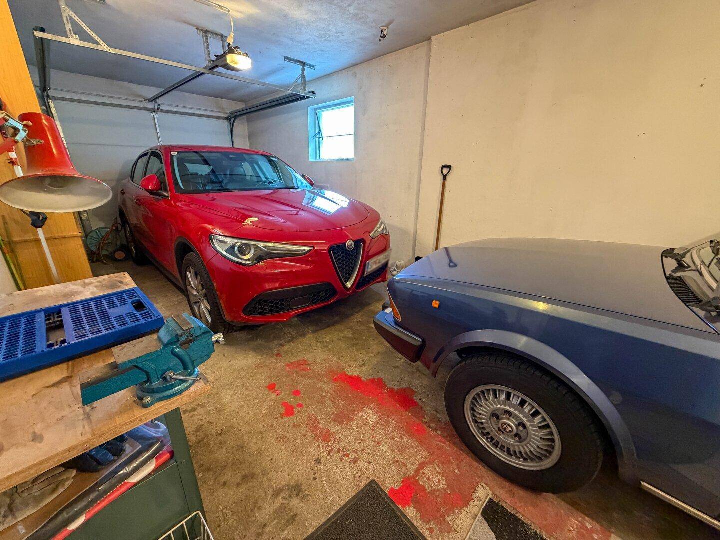 Geräumige Garage mit Platz für zwei Fahrzeuge und Werkzeugen.