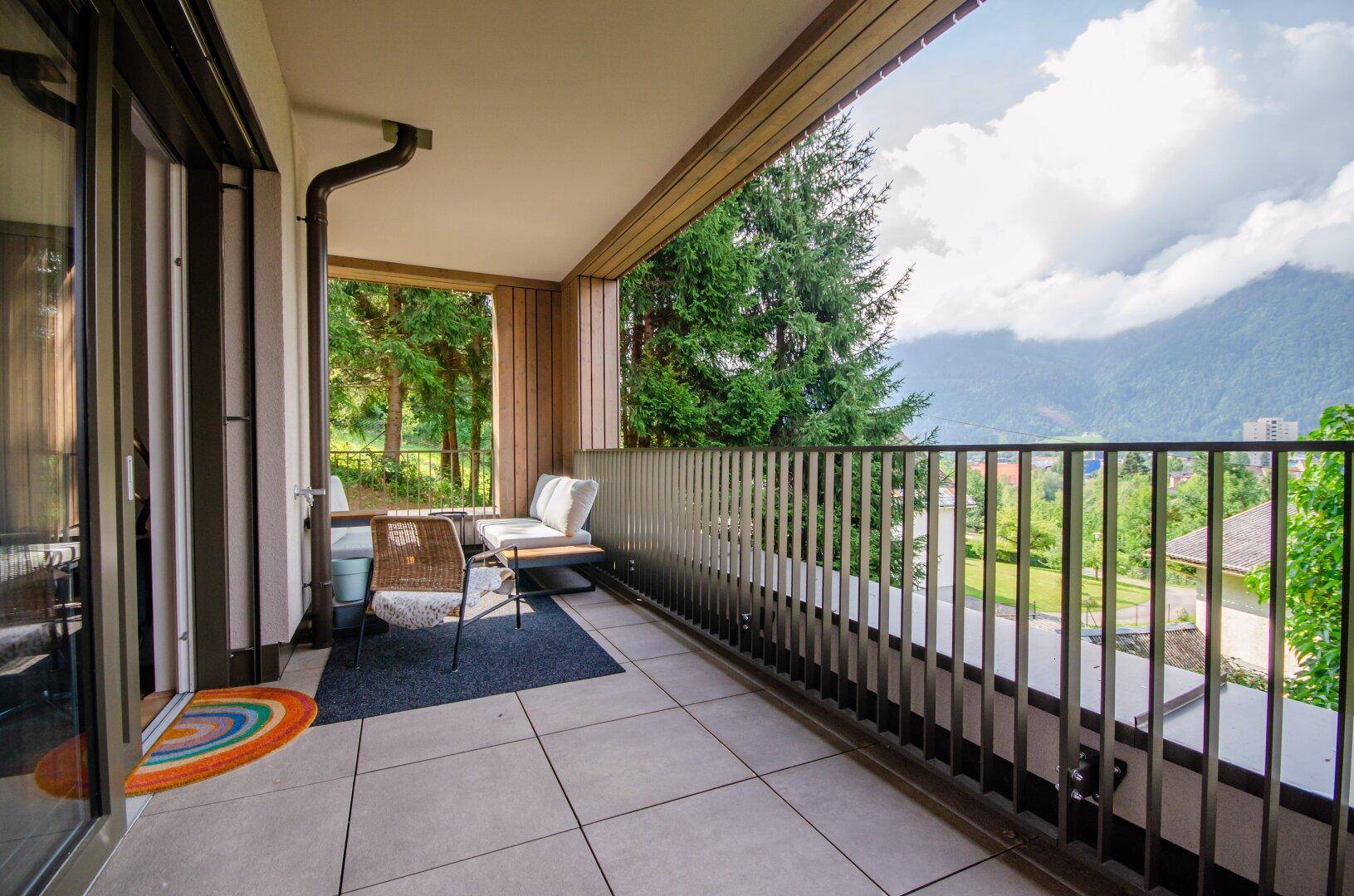 Geräumiger Balkon mit Sitzgelegenheiten und weitem Blick auf die umliegende Berglandschaft.