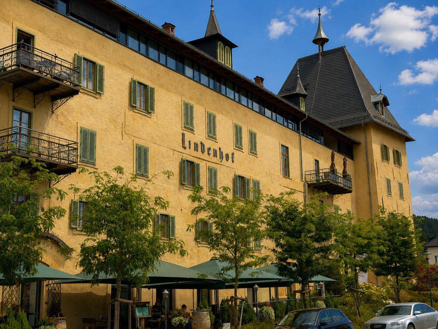 Detailansicht der gelben Fassade des historischen Gebäudes "Lindenhof" mit Balkonen und Außenbereich.