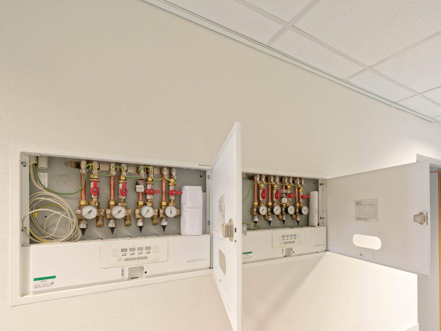 Technischer Raum mit offenem Verteilerkasten für Heizungs- oder Sanitärinstallationen.